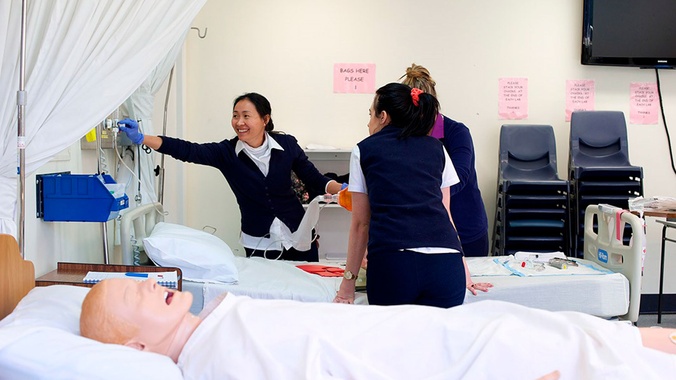 Students at bedside learning oxygen masks