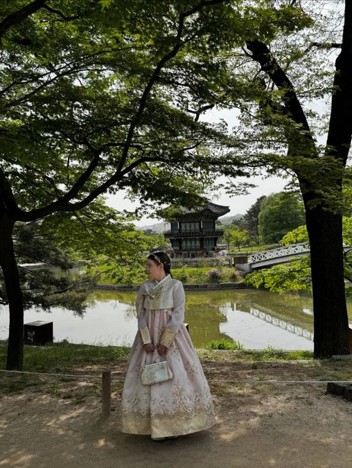 Student on overseas exchange, standing under tree.
