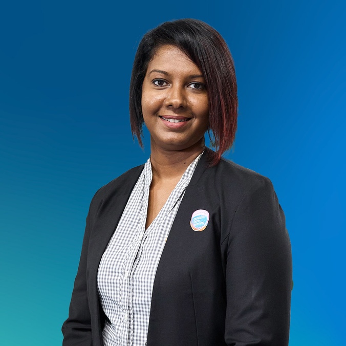 Woman dressed in a suit in front of a blue background