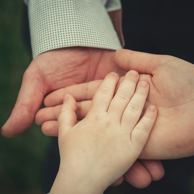 Hands of a man, woman and child