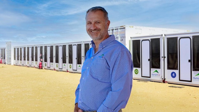 a southern cross alumni stands in front of temporary housing his company makes