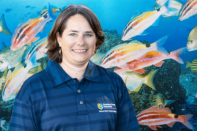 Professor Kirsten Benkendorff smiling in front of fish tank