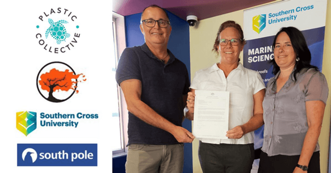 Three scientists holding a notice