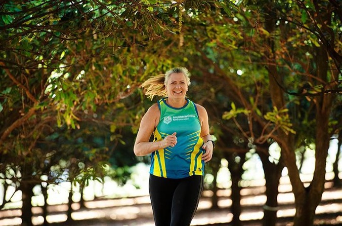 Kirsten Ellis running through macadamia orchard