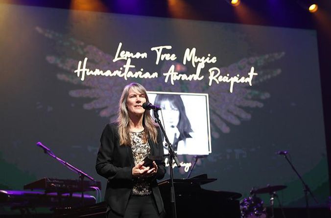 Leigh Carriage accepts Humanitarian Award at AWMA credit Embellysh