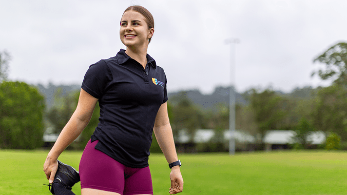 Student on field stretching leg