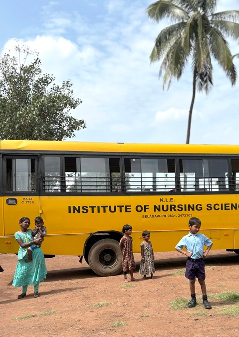 A small boy standing in front of a bus