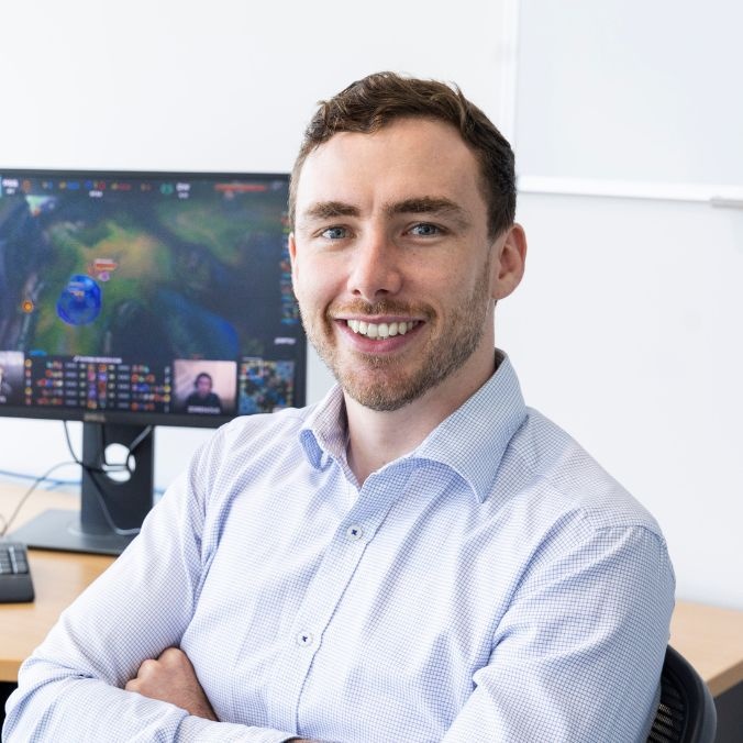 Dr Dylan Poulus sitting in front of computer