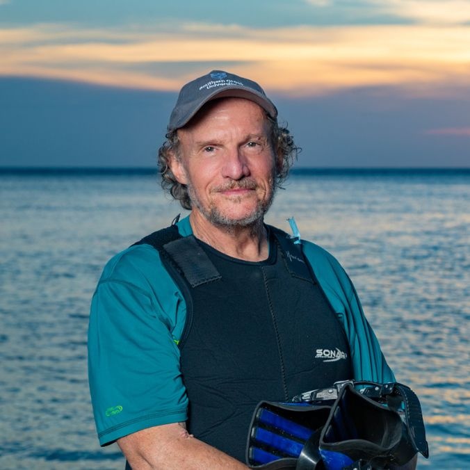 Professor Peter Harrison in front of ocean at sunset