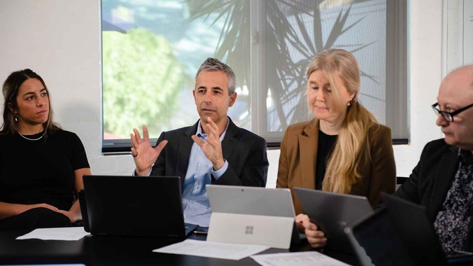 A group of health care practitioners discuss cases around a table