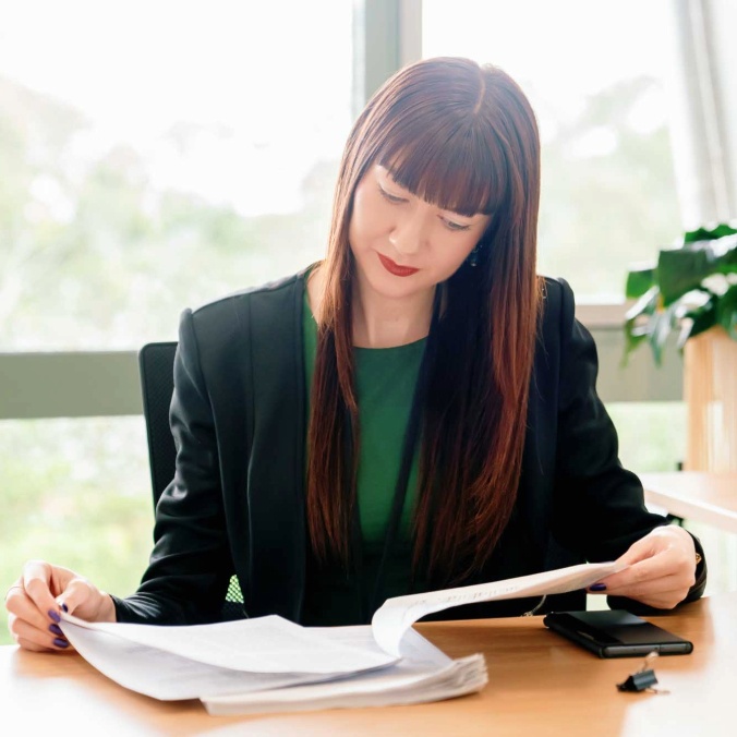 Professional woman sitting a desk looking at paperwork