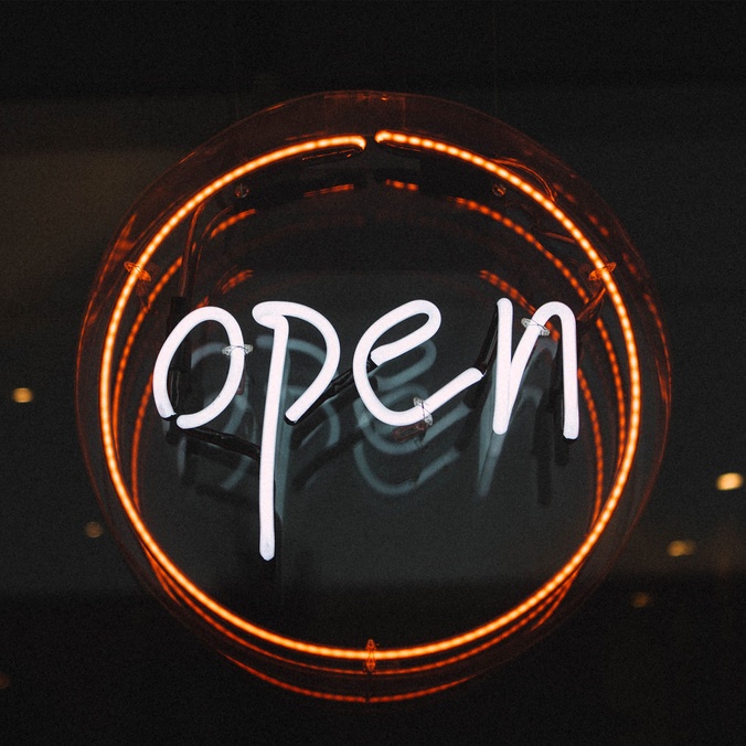 open sign spelled out in fluro circle