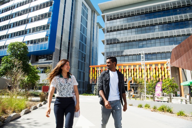 Two students walking in front of GC building