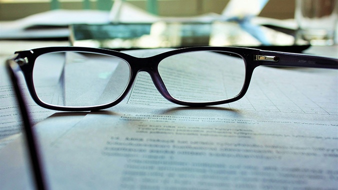pair of dark rimmed glasses resting on an open book - image source mari-helin-ilSnKT1IMxE-unsplash