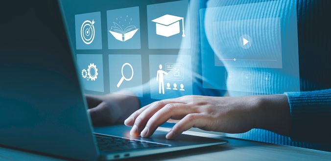 hands on a laptop keyboard with a transparent overlay of educational and technology icons hovering above the hands