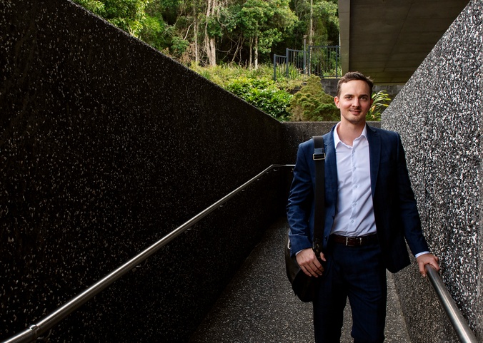 Law student graduate Tom Kershaw standing in front of the Southern Cross University Lismore campus Learning centre