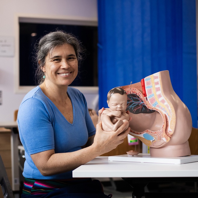 Georgina showing the model of a pregnant woman's anatomy