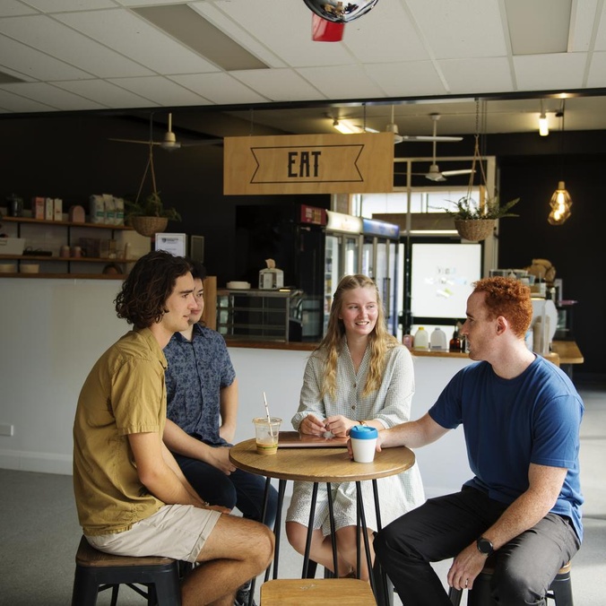 three students sitting having a drink