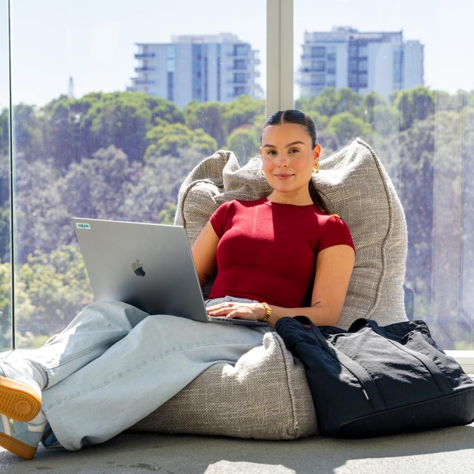 Business graduate Georgina at the Gold Coast campus with laptop
