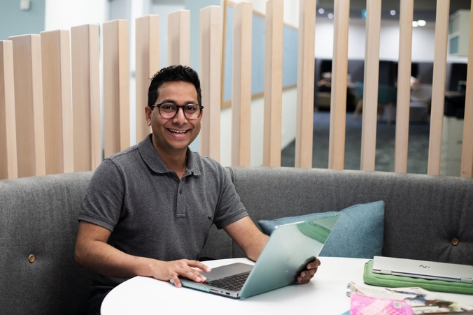 Shreyas Kale with laptop in the Gold Coast campus library