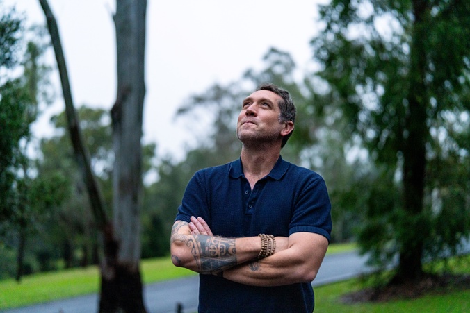 Renaud Joannes-Boyau standing outside looking up at the gumtrees at Lismore campus