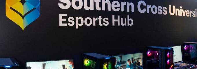 Computers along black wall with southern cross logo above it