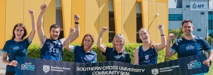 Runners holding a banner with arms in the air