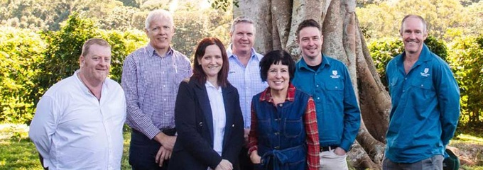 Group males and females standing in front of fig tree