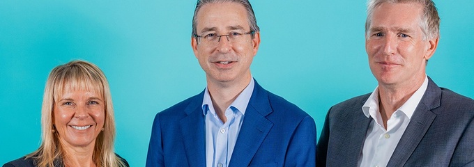 One woman and two men standing in front of a blue background