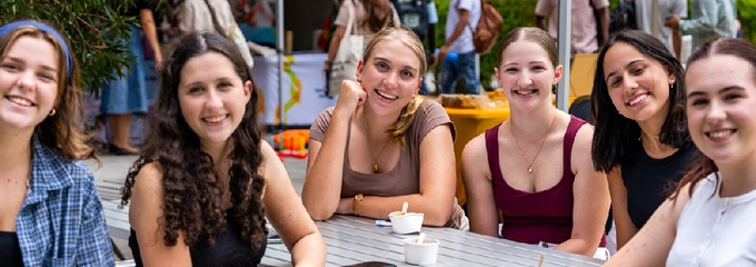 Group of female students sitting around a table at orientation day