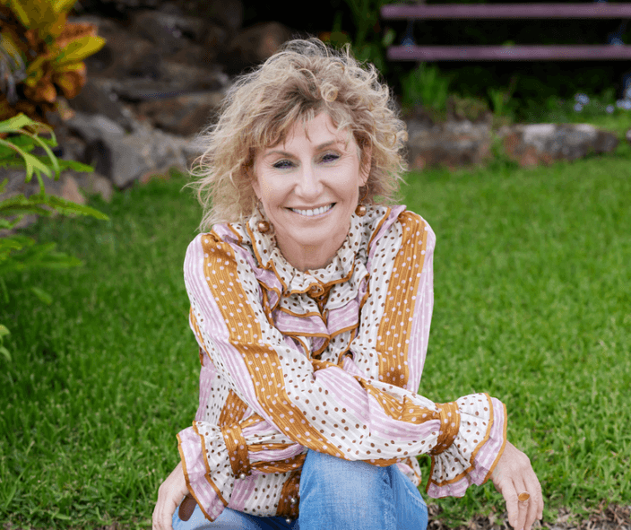 Sharon Styman sitting on the grass smiling