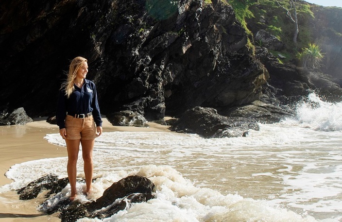 Girl standing in ocean looking out to sea