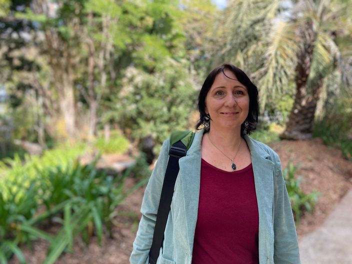 A woman in a garden looking at the camera