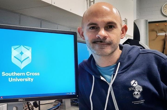 A man next to a computer screen