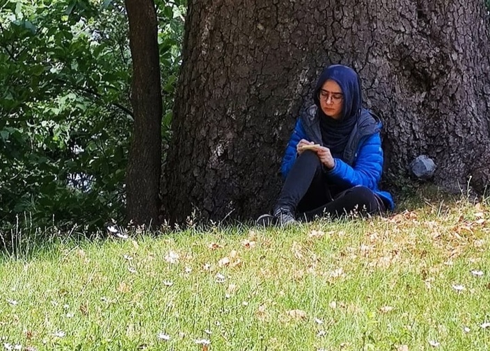 A student sitting under a tree