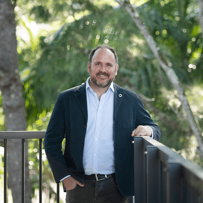 Professor Jon Wardle standing in front of greenery