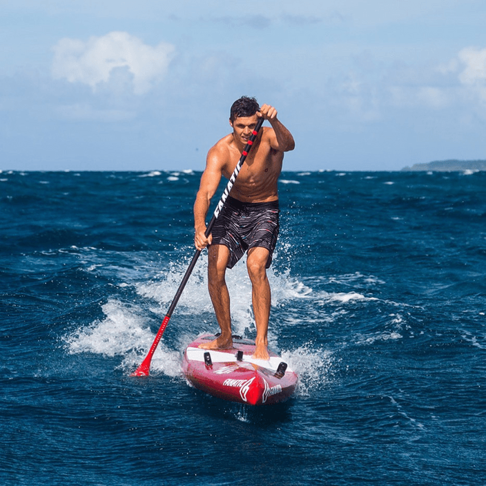 Jake Jensen rides a wave on a paddle board