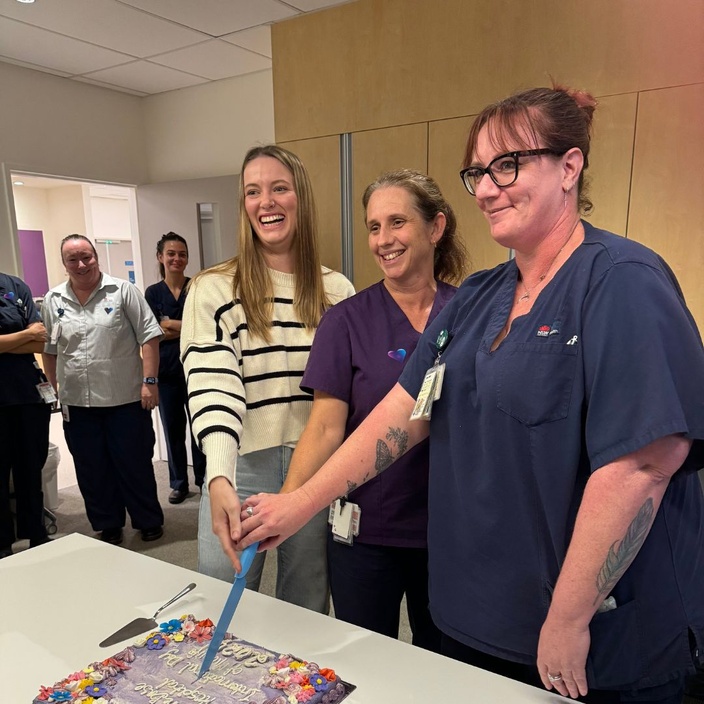 Three midwives cut a cake for International Day of the Midwife