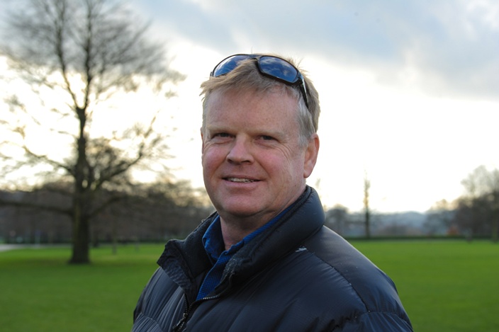 Man in jacket smiling at camera outside