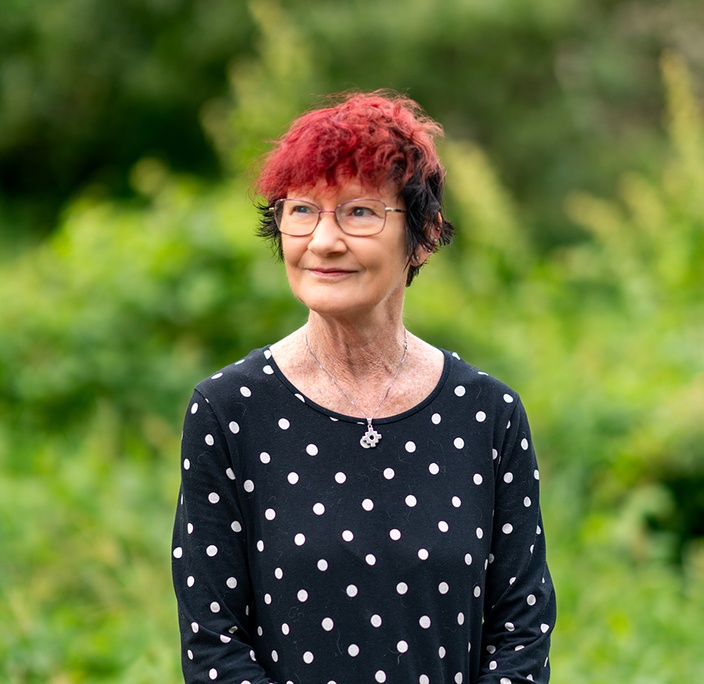 A woman looks off camera, green background