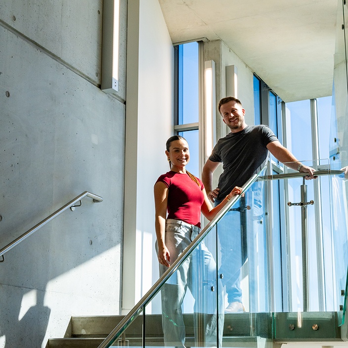 Business graduates Georgina Holt and Max O'Neil in Building B stairwell on the Gold Coast campus