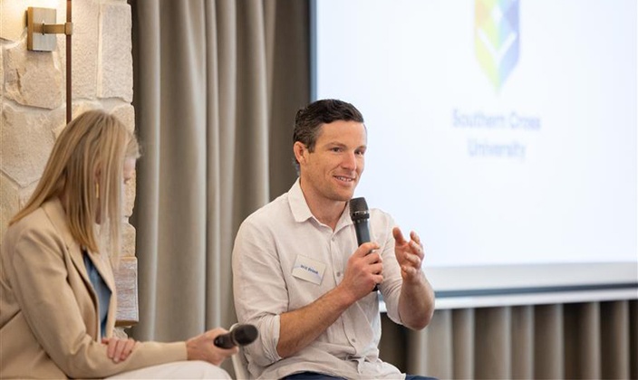 Man sitting and talking into microphone