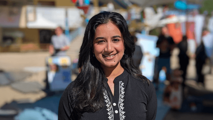 Student smiling at camera with long dark hair
