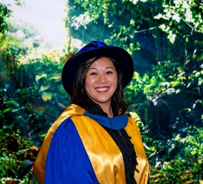 Woman smiling at camera in graduation robe