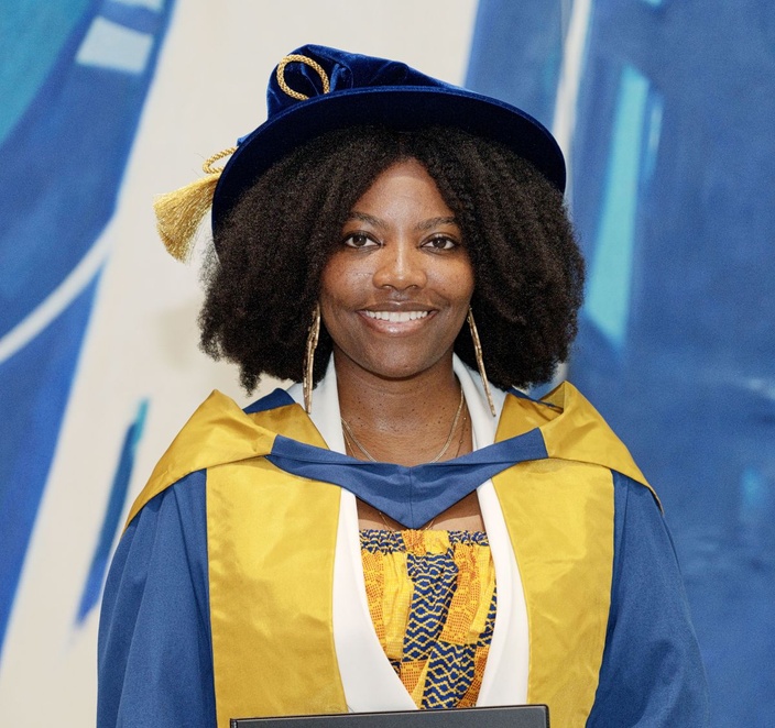 Women in graduation robe smiling at camera