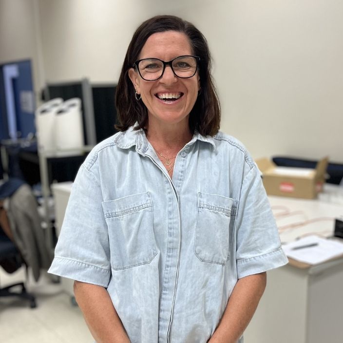 Woman in glasses smiling at camera
