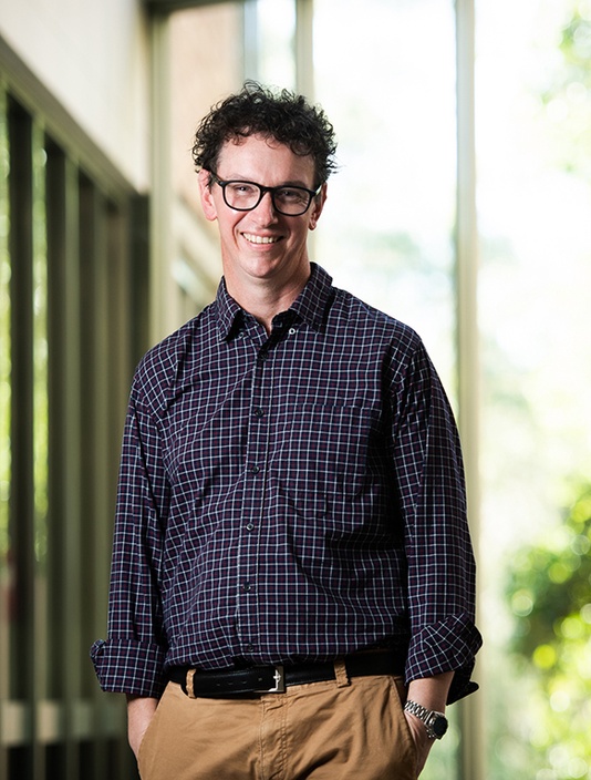 A man wearing a check shirt standing in a stairwell