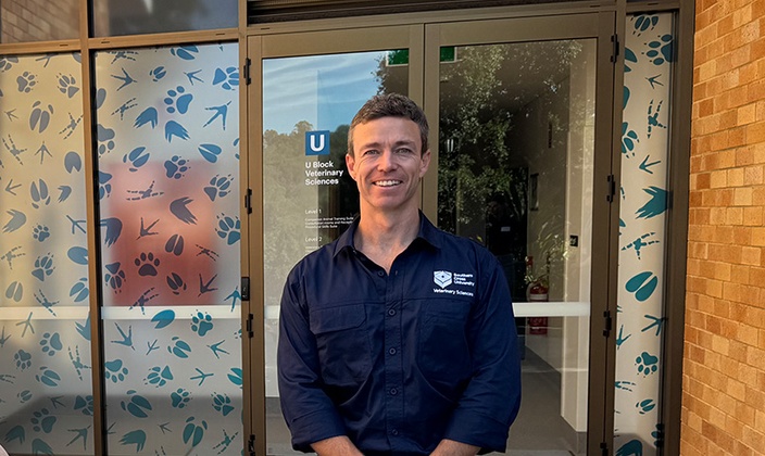 student in blue polo smiling