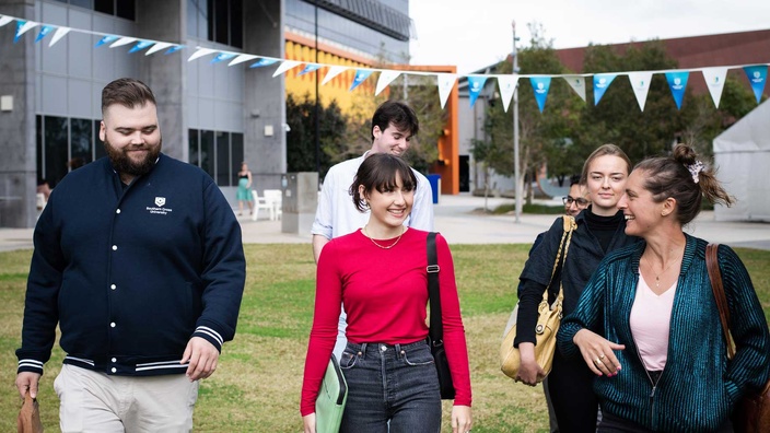 Students walking in grassy field at Gold Coast campus