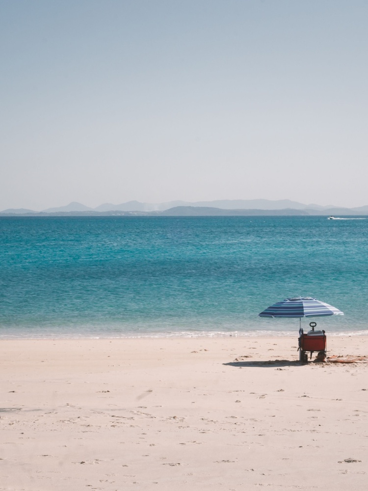Beach with umbrella and two chairs